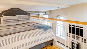 A bedroom with a bed, a window, and a radiator. - Industrial Chic Loft in the Heart of Downtown Richmond! (Richmond)