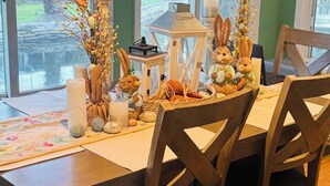 Een eettafel met stoelen, een kaars, een lantaarn en decoratieve accessoires.