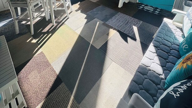 Een zonnedekenruimte met een tafel, stoelen, een bank en uitzicht op de omgeving.