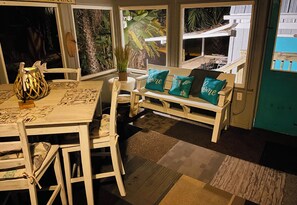 Relax in a charming room with a wooden table, woven lamp, and botanical prints.