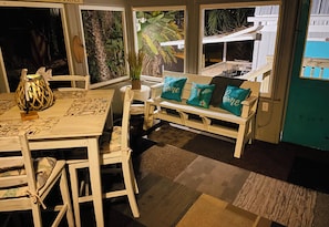 Relax in a charming room with a wooden table, woven lamp, and botanical prints.
