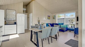A spacious kitchen with a dining area, a sofa, and a TV.