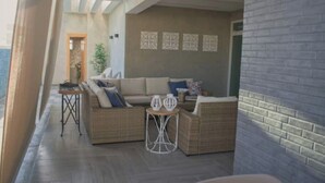 Ein modernes Wohnzimmer mit Ecksofa, einem kleinen runden Tisch und Wandbildern.