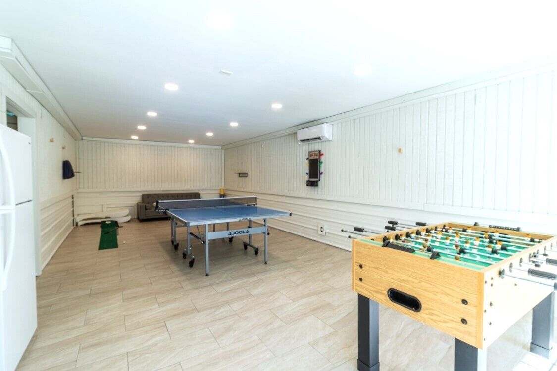 Une pièce équipée d’une table de ping-pong, d’un baby-foot et d’un canapé.