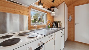 A modern kitchen with a stainless steel stove, a sink, and wooden cabinets. - Beautiful home in Nexø with kitchen (Nexø)