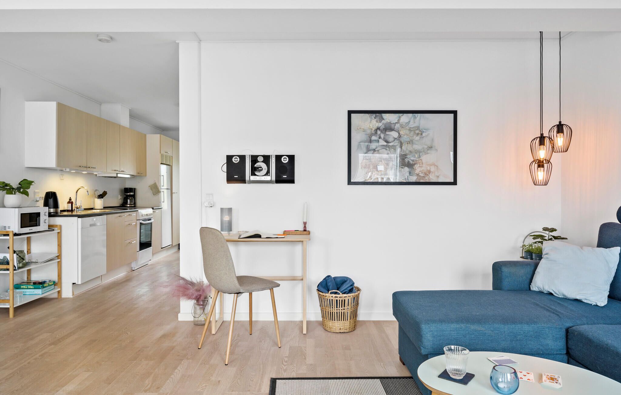 En moderne lejlighed med køkken, spiseplads og opholdstue.