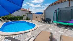 A backyard with a swimming pool, outdoor furniture, and a trampoline. - Gorgeous apartment in Banjevci (Banjevci)
