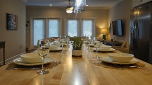 A dining room with a long table set for a meal, a ceiling fan, and a refrigerator. - 5min Walk to Beach, Free Golf Cart, Pool, Luxe Townhome (Miramar Beach)