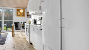 Eine moderne Küche mit weißen Schränken, einem Backofen und einer Kaffeemaschine.