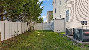 A residential area with a fenced yard, trees, and a building with air conditioning units. -  JANUARY-MAY 3 NIGHT MIN 2026 5 Bedroom3 bath 1 block to the beach and boards (Wildwood)
