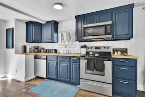 Modern kitchen with a central island, appliances, and a window above the sink.