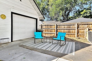 Enjoy outdoor relaxation on the patio with two comfortable chairs and a small table.