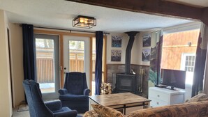A cozy living room with a fireplace, a television, and a sofa.