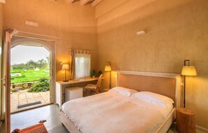 Relax in this serene bedroom with a large bed, two bedside tables, and a desk area.