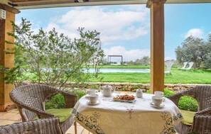 Guests can enjoy a tranquil tea setting amidst lush surroundings and a serene pool view.