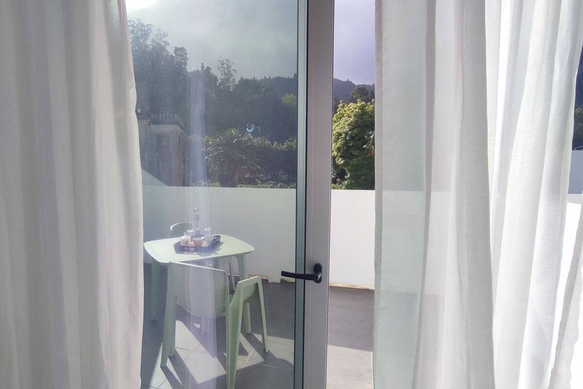Una habitación con puerta de cristal corredera que da a un balcón exterior.