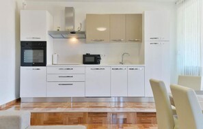 Enjoy cooking and dining in this kitchen with oven and microwave, complemented by a herringbone floor.