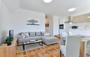 Relax in this cozy living space with a sofa, dining area, and kitchenette.