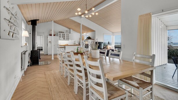 Una cocina amplia con alacenas blancas, una mesa de comedor de madera y un gran ventanal con vistas.