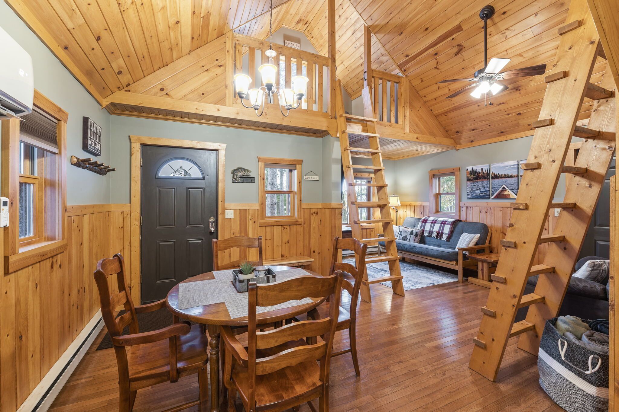 Un interior de madera con comedor, sofá y escalera.