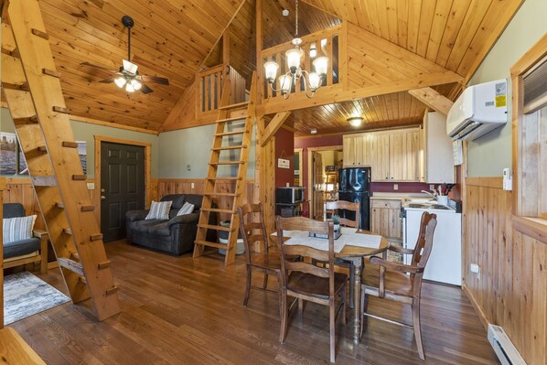 Un intérieur en bois comprenant un coin repas, une cuisine et un espace de vie.