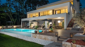 A modern two-story house with a swimming pool, outdoor seating, and a well-lit patio area. - Lovely home in Zminj with sauna (Zminj)