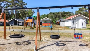 A playground with swings, tire swings, and a slide. - 2 bedroom cozy home in Nexø (Nexø)