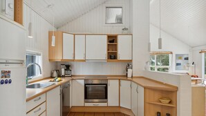 A compact kitchen with white cabinets, a built-in oven, and a sink. - Awesome home in Aakirkeby with WiFi (Aakirkeby)