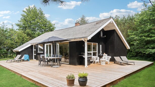 A wooden deck with a dining area, outdoor grill, and lounge chairs. - Awesome home in Aakirkeby with WiFi (Aakirkeby)