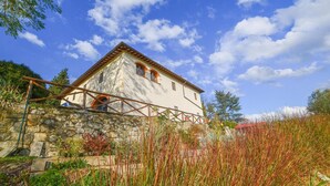 A rustic stone bridge leading to a white building with a red-tiled roof, surrounded by lush greenery and tall grasses. - Stunning apartment in Rignano sull'Arno (Rignano sull'Arno)