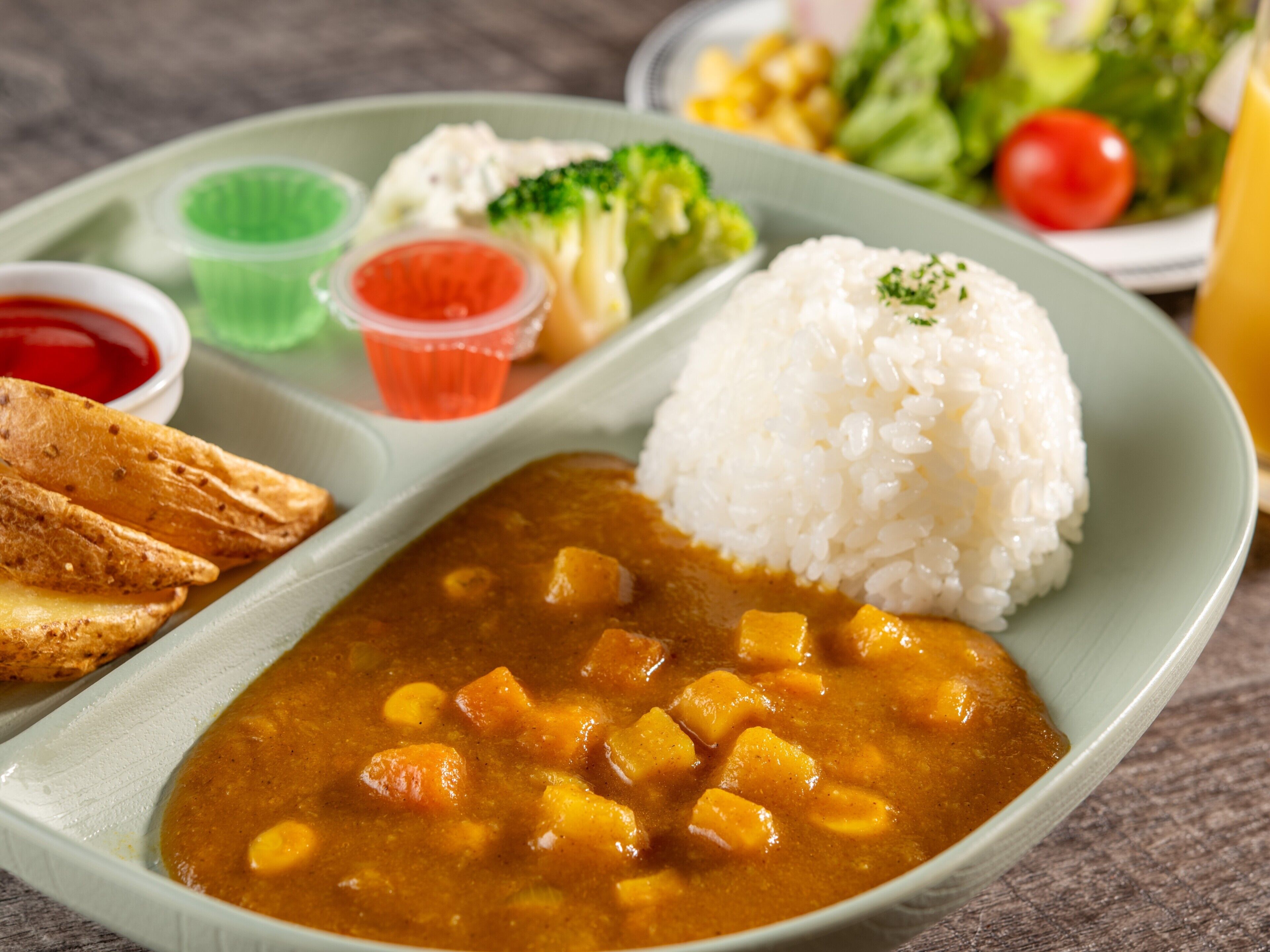 A plate with rice, a curry dish, a side of bread, and a small bowl of sauce.