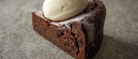 A slice of chocolate cake with a scoop of vanilla ice cream on top.