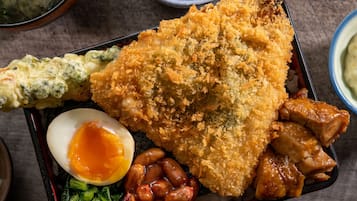 A traditional Japanese meal with a variety of dishes including fried fish, a boiled egg, pickled vegetables, and a side of miso soup.