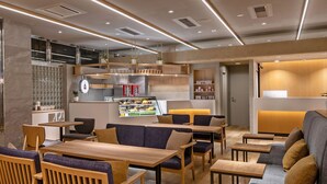 Un intérieur moderne avec des meubles en bois, une machine à café et un coin salon offrant une vue sur la cuisine.