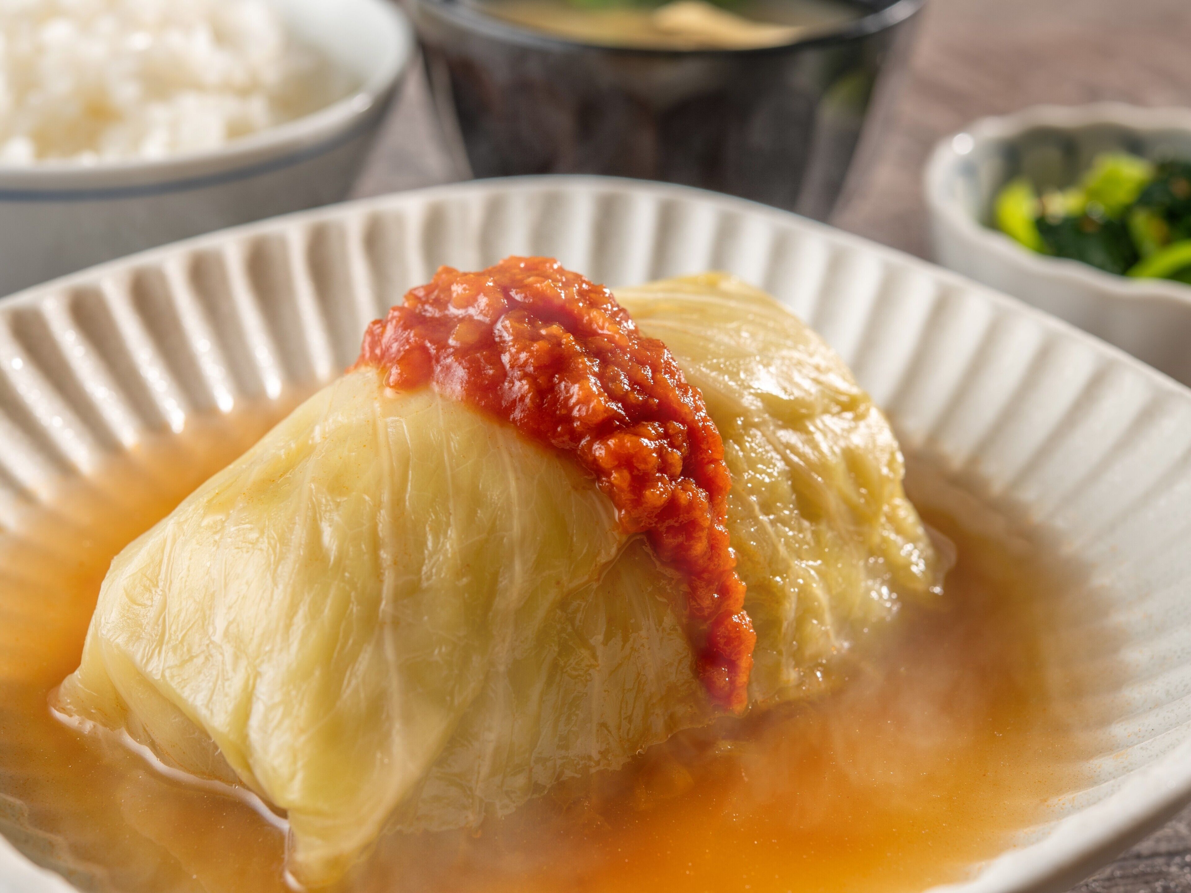 A dish of cabbage rolls in a white bowl.