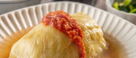A dish of cabbage rolls in a white bowl.