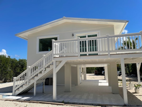 A two-story house with a balcony and a staircase leading to the upper floor.