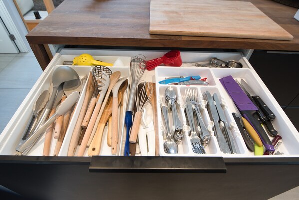 Un cajón con diversos utensilios y herramientas de cocina.