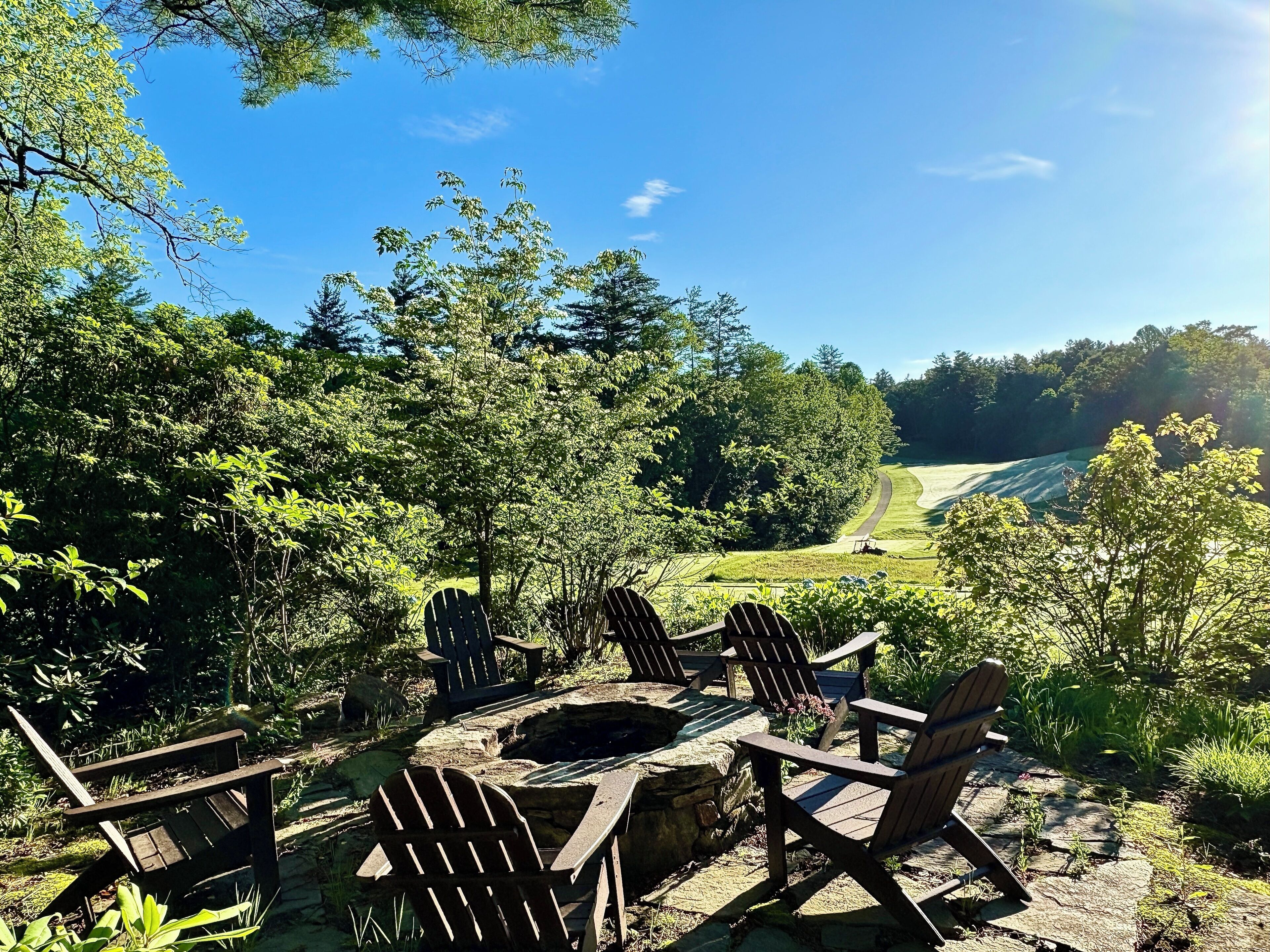 Stone fire pit with Adirondack chairs -open views of golf course