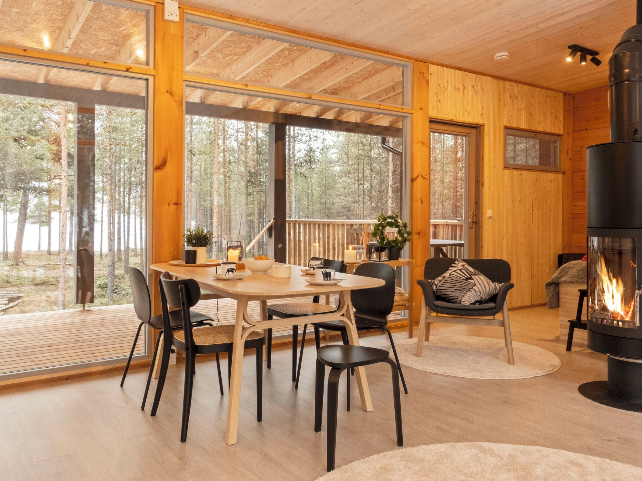 A cozy cabin interior with a dining area, seating, and a fireplace.