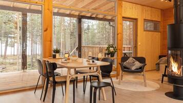 A cozy cabin interior with a dining area, seating, and a fireplace.