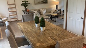 Ein Essbereich mit Holztisch, gepolsterten Bänken und einer Couch.