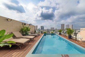 A rooftop pool with lounge chairs and potted plants, overlooking a cityscape. - A25 Premium Hotel - 29 Le Thi Hong Gam     (Ho Chi Minh City)