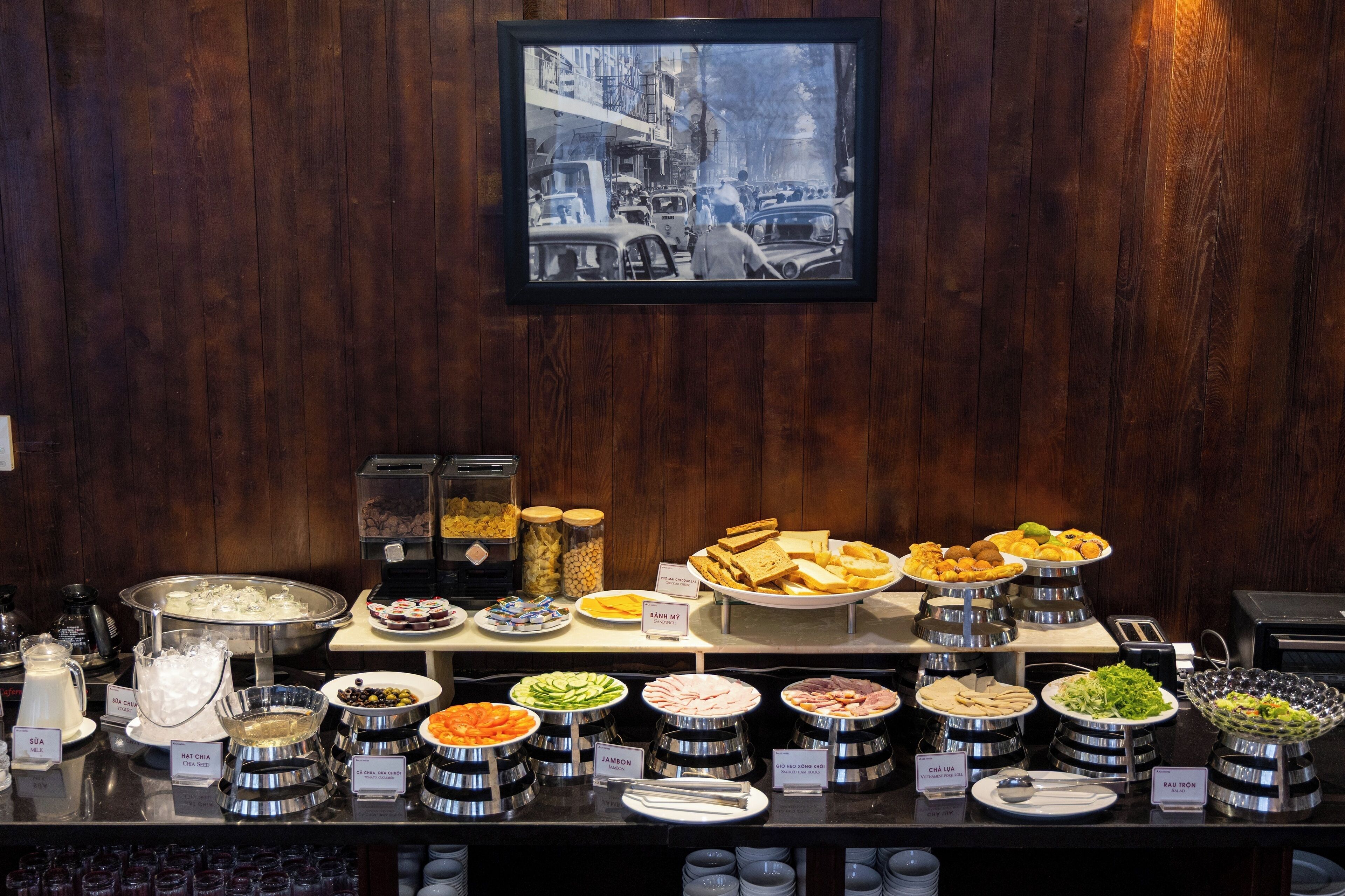 Un bufé con diversas opciones de comida y una fotografía antigua en la pared.