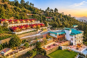 Hotel amb diverses edificacions, zones d'estar a l'exterior i vistes a un paisatge montanyós.