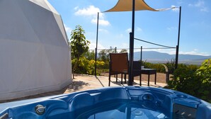 Un jacuzzi con muelle de madera, una silla y un dosel.