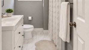 Ein Badezimmer mit Toilette, Waschbecken und Duschvorhang.