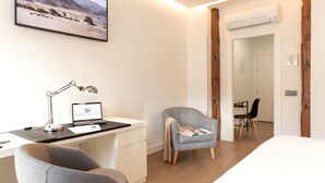 Una habitación de hotel moderna con escritorio, silla y cama.
