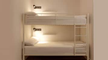 A bunk bed with a bedside table and a wall-mounted light fixture.
