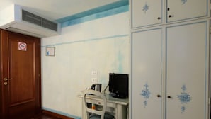 A room with a wooden door, a white desk with a computer, and a white wardrobe with floral designs. - Hotel ai do Mori (Venice)